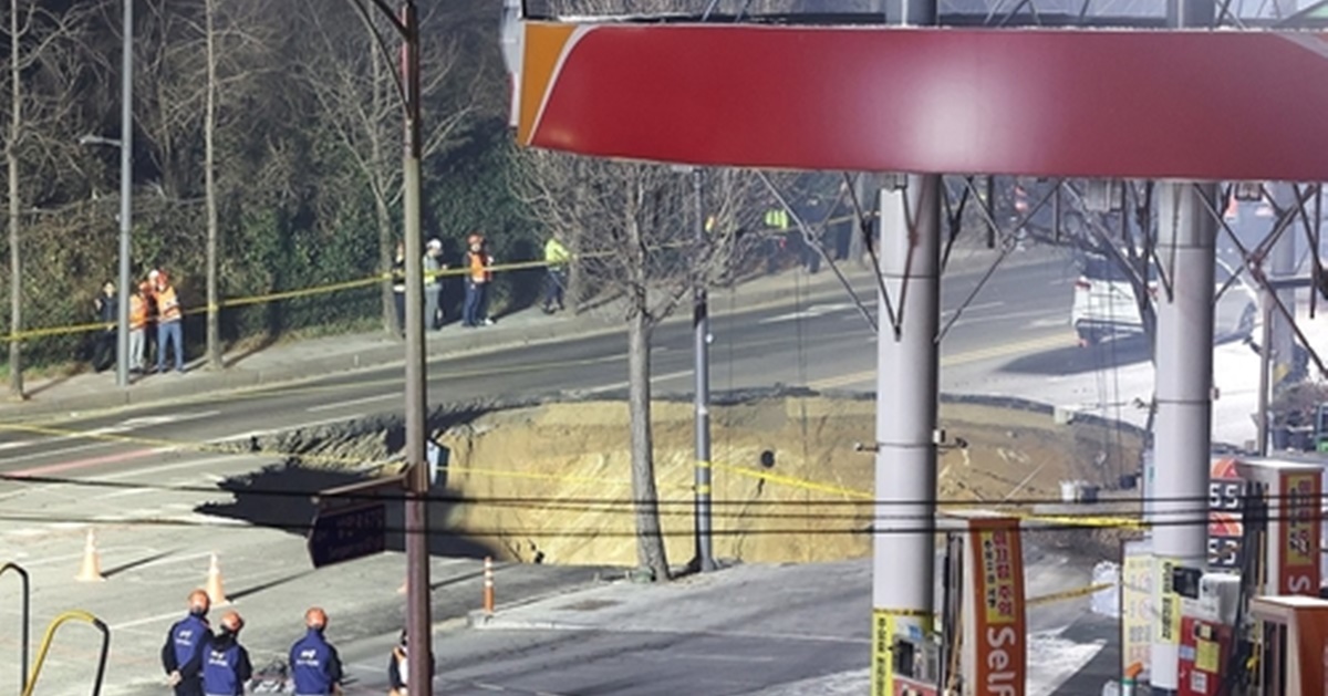 Rescue authorities inspect a sinkhole at an intersection in Seoul's eastern ward of Gangdong