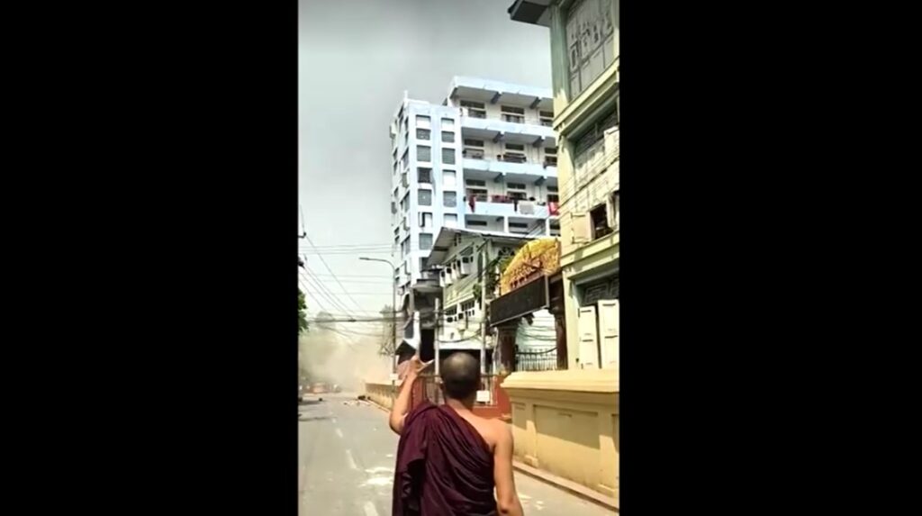 Building before collapses in Myanmar in front of monk's eye