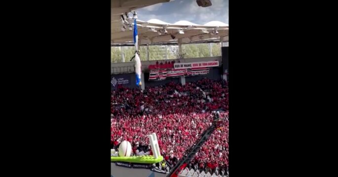Parachutist dangling from rugby stadium roof