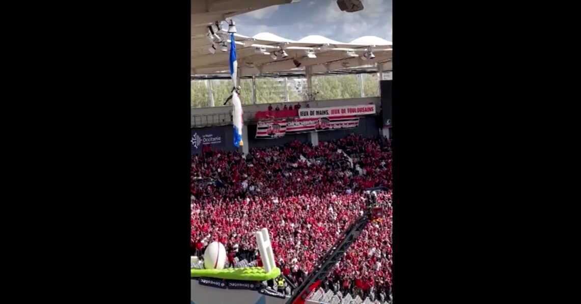Parachutist dangling from rugby stadium roof