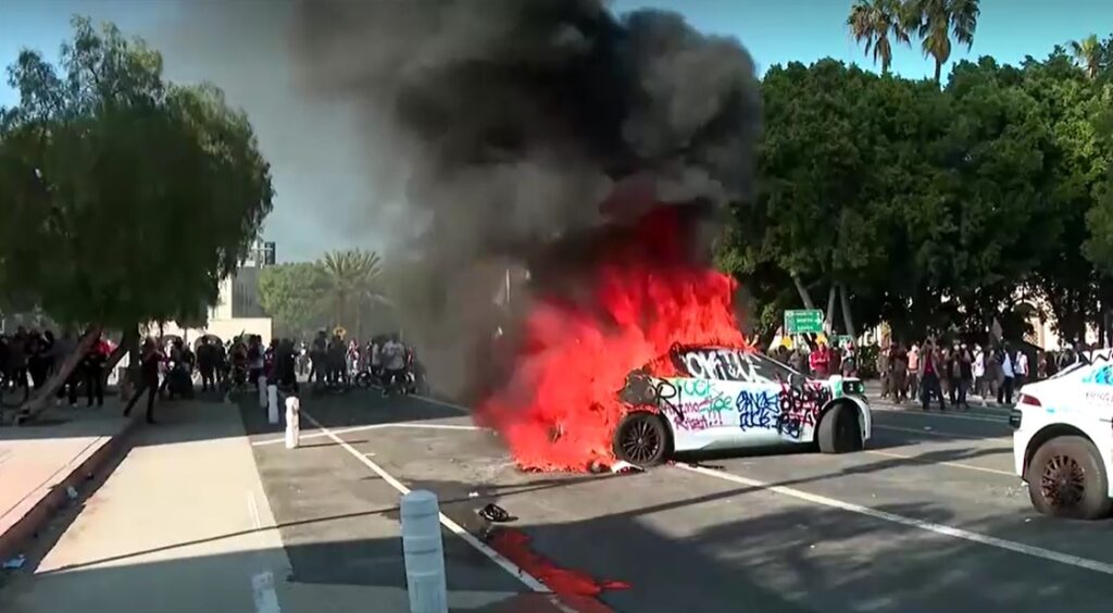 protesters burn car in protest against ICE in LA